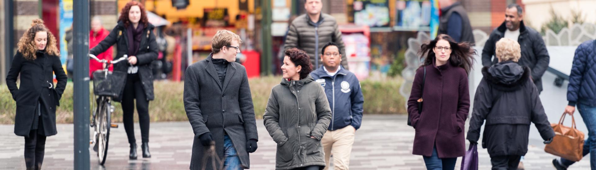 diverse mensen lopen over straat